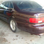 Before and after photographs of a damaged Chevy Impala that was repaired by Elite Paint & Body Shop in West Palm Beach, Florida.